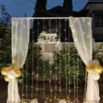 Elegant Fairy Light Birthday Backdrop | White Curtain & Golden Balloon Decoration